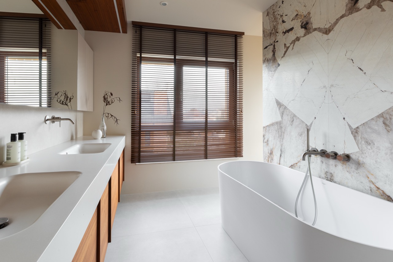 Freestanding bathtub with marble wall